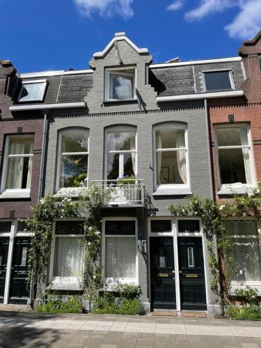 Bed and Breakfast Amsterdam في أمستردام: منزل رمادي بنوافذ بيضاء على شارع