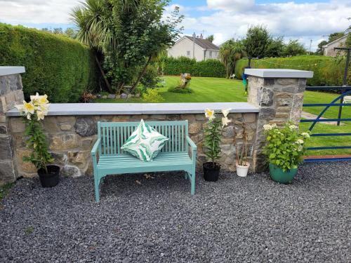 un banc bleu avec un oreiller assis à côté d'un mur en pierre dans l'établissement Brielle House, à Mountmellick