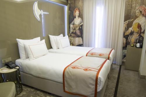 a hotel room with two beds and a painting on the wall at Peyk Hotel in Istanbul