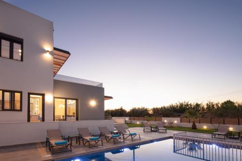 Pigianos KamposにあるSunnyside Villas, Just Steps to the Beach & Restaurants, By ThinkVillaのスイミングプール、パティオ家具が備わるヴィラです。