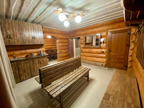 - un banc en bois dans une chambre avec une cuisine dans l'établissement Complex MAYARIV, à Makariv