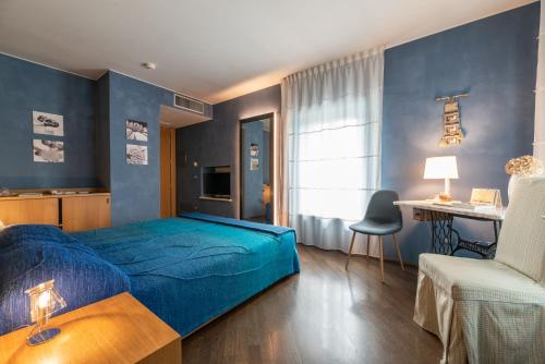 a blue bedroom with a bed and a chair at Hotel Suite Inn in Udine