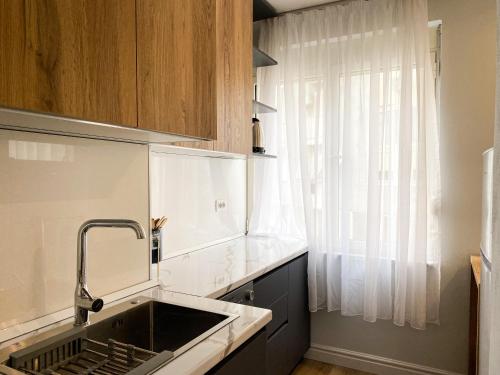 cocina con fregadero y ventana en Centrally located Glamorous Bright APT near Bazaar, en Tirana