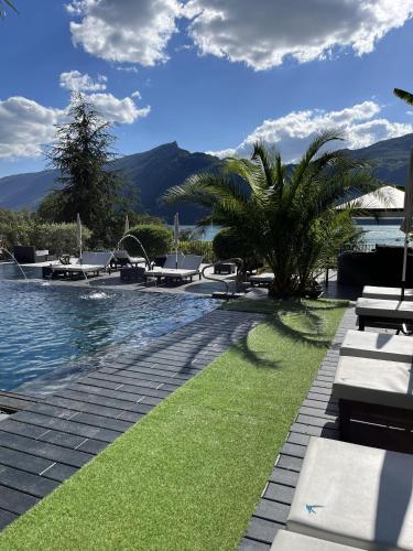 a swimming pool with a palm tree next to a resort at Les Suites du Lac in Aix-les-Bains