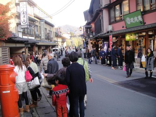 a crowd of people standing on a busy city street at Morizuya in Toyooka