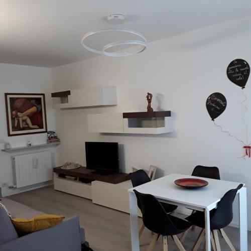 a living room with a white table and chairs at OLTRE LE NUVOLE in Cuneo
