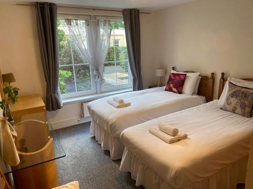 two twin beds in a room with a window at Hopetoun Apartment with free parking in Edinburgh