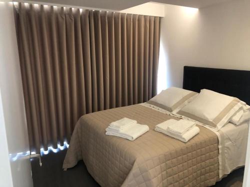 a bedroom with a bed with towels on it at Apartamento Deluxe AM in Faro