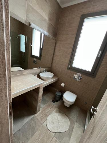 łazienka z umywalką, toaletą i oknem w obiekcie Ville con vista w mieście Drymon