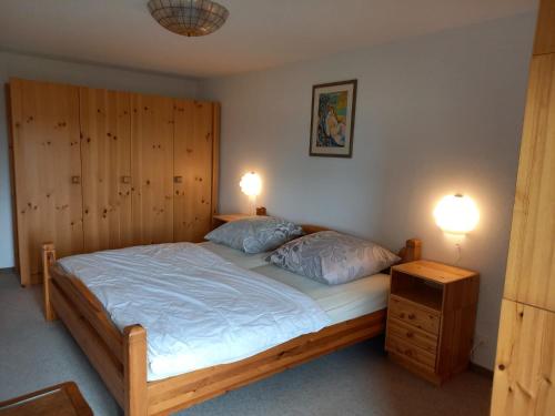 a bedroom with a large wooden bed with two pillows at Casa di vacanza in Capriasca ( Lugano ) in Bidogno