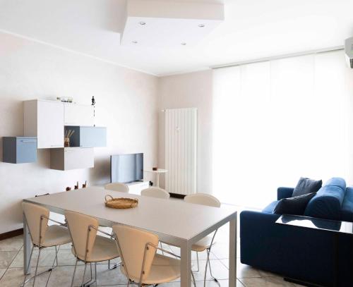 ein weißes Esszimmer mit einem Tisch und Stühlen in der Unterkunft BLUE LAKE ARONA - cozy apartment in city center in Arona