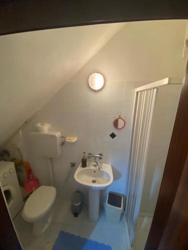 a bathroom with a white toilet and a sink at Casa Fontanelle in Burgio