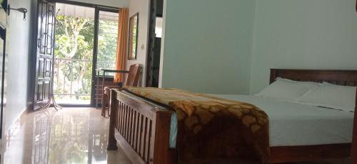 a bedroom with a bed and a sliding glass door at BENIEL HOMESTAY in Suryanelli