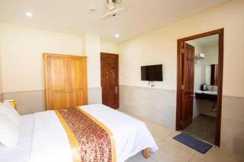 um quarto com uma cama e uma televisão em California Hotel em Ho Chi Minh