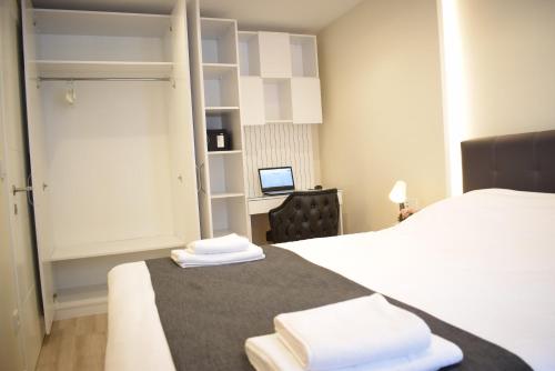 1 dormitorio con 1 cama y escritorio con ordenador en Scope Apartment, en Estambul