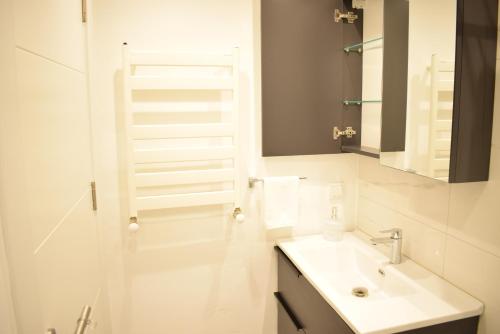 a white bathroom with a sink and a mirror at Scope Apartment in Istanbul