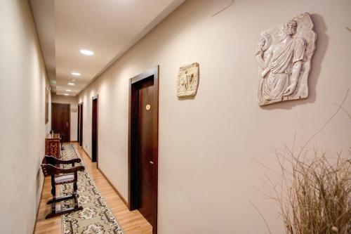 a hallway with a wall with a statue on the wall at Hotel Roma Tiburtina Metro in Rome