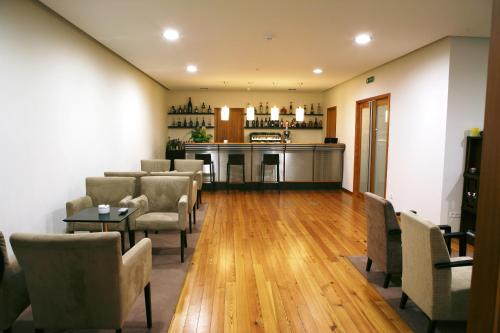 a waiting room with chairs and a bar in the background at Hotel Quinta Progresso in Macieira de Cambra