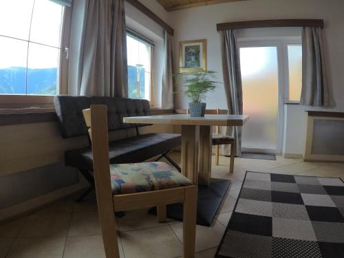 a living room with a table and a chair at Hotel-Garni Seestrand in Zell am See