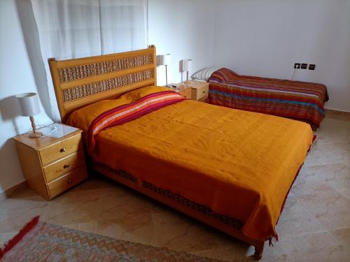 um quarto com uma cama grande e uma mesa de cabeceira em Dar Albatros em Sidi Kaouki