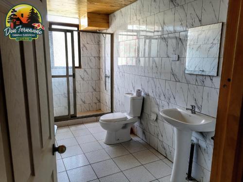 a bathroom with a toilet and a sink at Cabañas Don Fernando in Laguna Verde