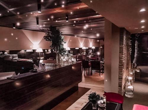 un restaurante con un bar con mesas y sillas en LEAR • Dining Club, en Briosco