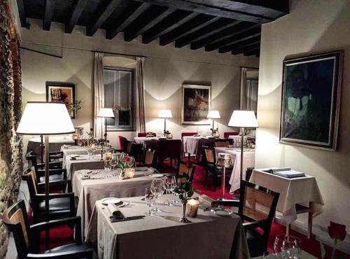 un restaurante con mesas y sillas con manteles blancos en LEAR • Dining Club, en Briosco