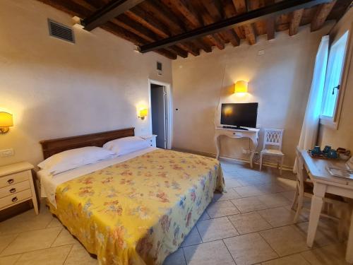 a bedroom with a large bed and a television at Agriturismo San Michele in Vicenza