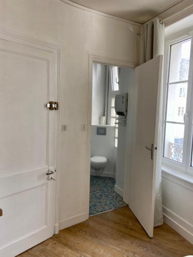 une salle de bain blanche avec toilettes et fenêtre dans l'établissement Bro’ Flat appartement au calme Cherbourg Centre, à Cherbourg en Cotentin