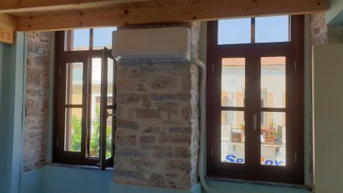 two windows in a room with a brick wall at Christos Katerina House in Pythagoreio