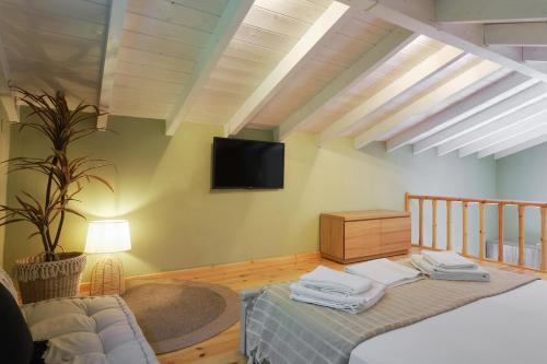 Heliotopos في سكالا إيريسو: غرفة نوم مع سرير وتلفزيون على الحائط
