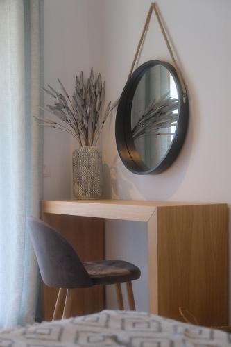 a mirror hanging on a wall next to a chair at Heliotopos in Skala Eresou