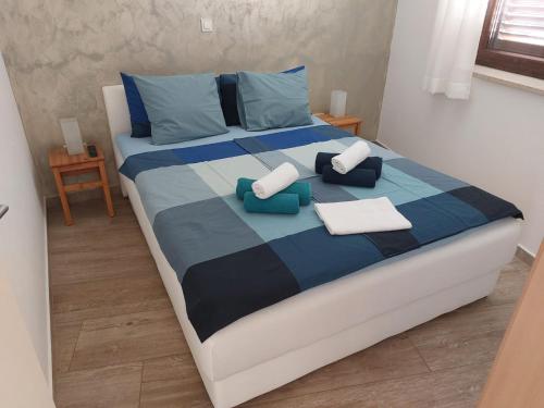 een slaapkamer met een groot bed met blauwe kussens bij Apartment Marija in Njivice