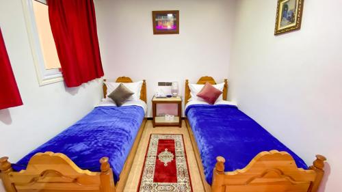 two beds in a room with blue sheets at Hotel EL MARSA LA PLAYA in Laayoune