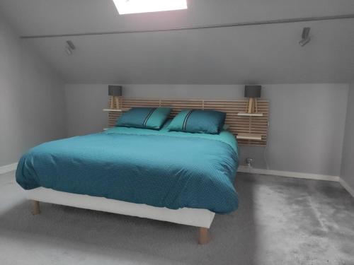 1 dormitorio con 1 cama con mantas y almohadas azules en Appartement cosy centre-ville wifi parking en Charleville-Mézières
