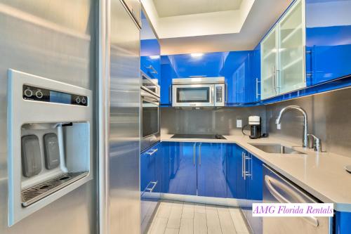 フォート・ローダーデールにあるLuxury 1 BR at Fort Lauderdaleのキッチン(青いキャビネット、ステンレス製の冷蔵庫付)