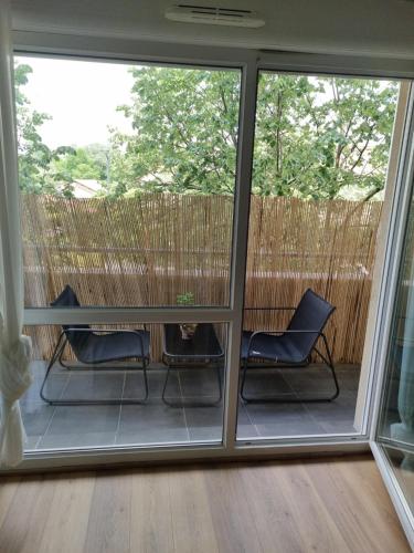 - une véranda avec 2 chaises et une table dans l'établissement Appartement 2 pièces de Charme à d'Annemasse., à Annemasse