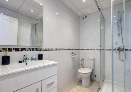 uma casa de banho com um WC, um lavatório e um chuveiro em Quaint 2 Bedroom Townhouse with Pool close to Sea! em Benalmádena