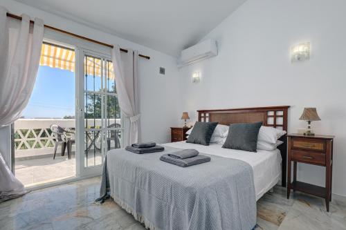 um quarto com uma cama e vista para o oceano em Quaint 2 Bedroom Townhouse with Pool close to Sea! em Benalmádena