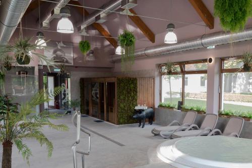 a lobby with a table and chairs and plants at Hercegasszony Birtok in Mezőtúr