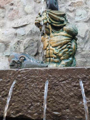 a statue of a lion sitting next to a fountain at Casona Mollepata in Mollepata