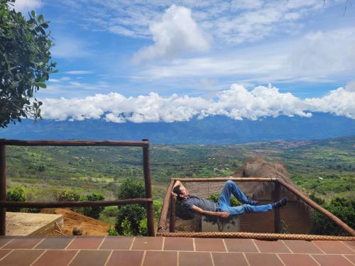 a person laying on a roof with a view at Hotel Cariguá in Barichara