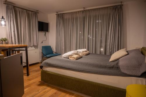 a bedroom with a bed and a window with a chair at Hercegasszony Birtok in Mezőtúr