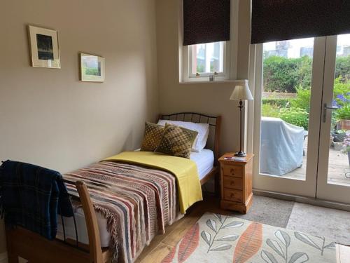 een slaapkamer met een bed en een glazen schuifdeur bij Braid Rd Stunning Villa in Edinburgh