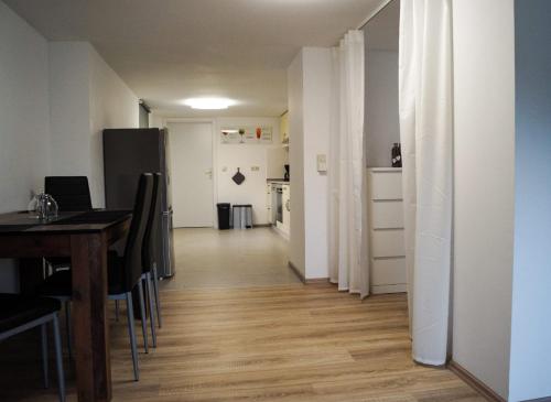 a room with a dining table and a hallway with a kitchen at Wohlfühlen am Großen Goitzschesee in Holzweißig