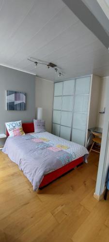 une chambre avec un grand lit dans une pièce dans l'établissement Appartement coquet sur les hauteurs de Montmartre, à Paris