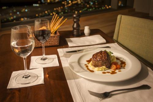 a table with a plate of food and two glasses of wine at Arakur Ushuaia Resort & Spa in Ushuaia