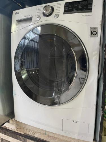 a white washing machine sitting in a room at hospedaje de marant 3 in San Felipe de Puerto Plata