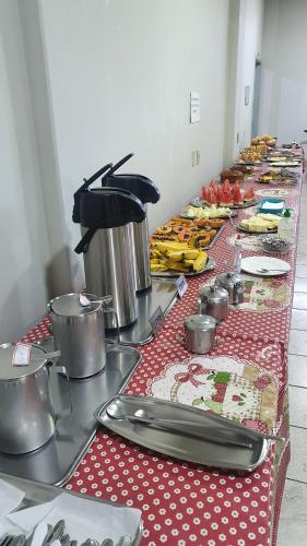 a long table with a red and white table cloth at POUSADA POLONINI - Localização ótima in Piúma