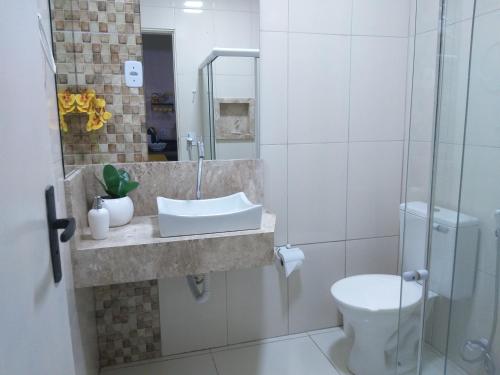 a bathroom with a sink and a toilet at Flor de Peroba Flats #1 Amarelo - Maragogi - AL in Maragogi